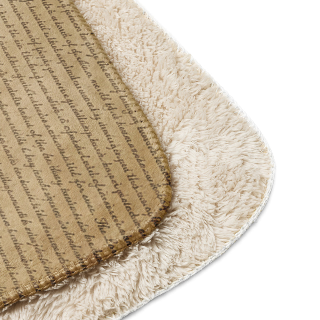 Close-up of a tan Luxury Sherpa Throw Blanket showing a soft, plush sherpa side and a smooth side with cursive script pattern, highlighting its premium, elegant texture.