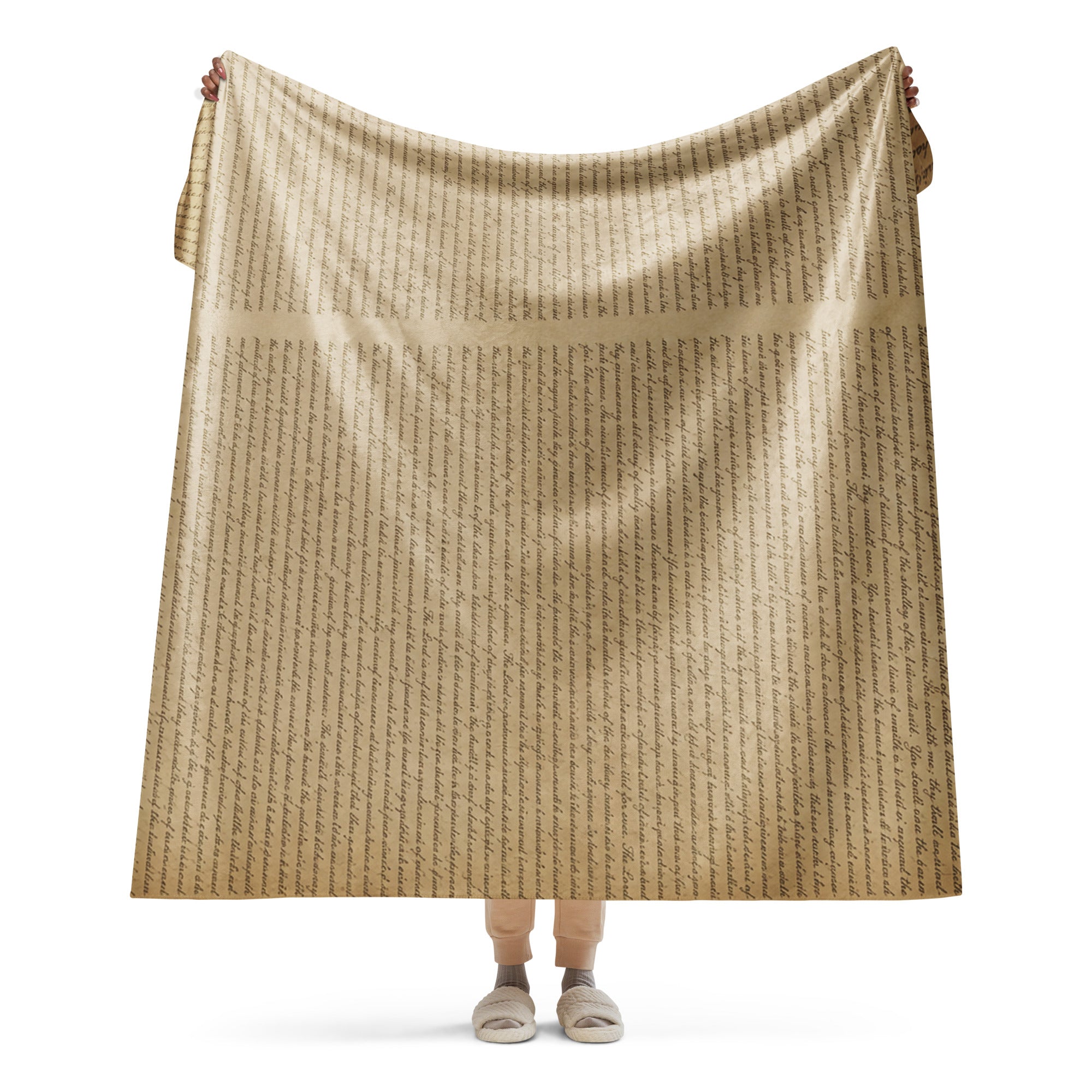 Person holding a tan Luxury Sherpa Throw Blanket with a subtle elegant script pattern, showcasing its soft, premium texture and cozy design.